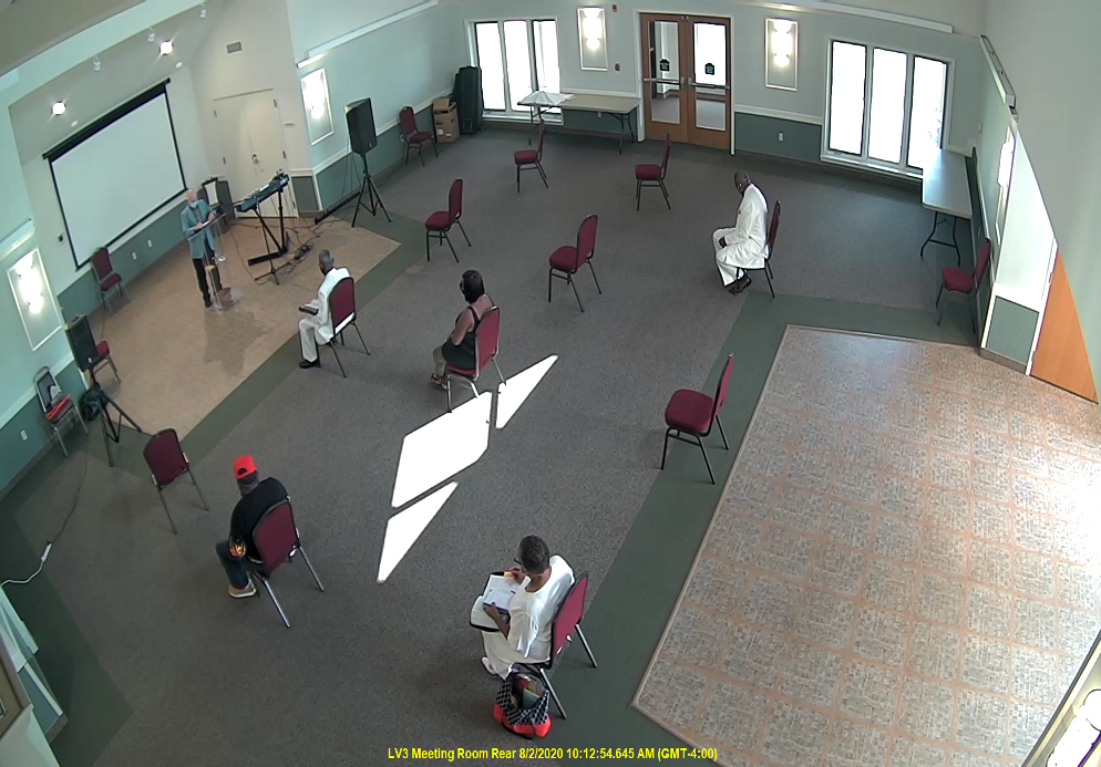 A group of people sitting in chairs in an empty room.